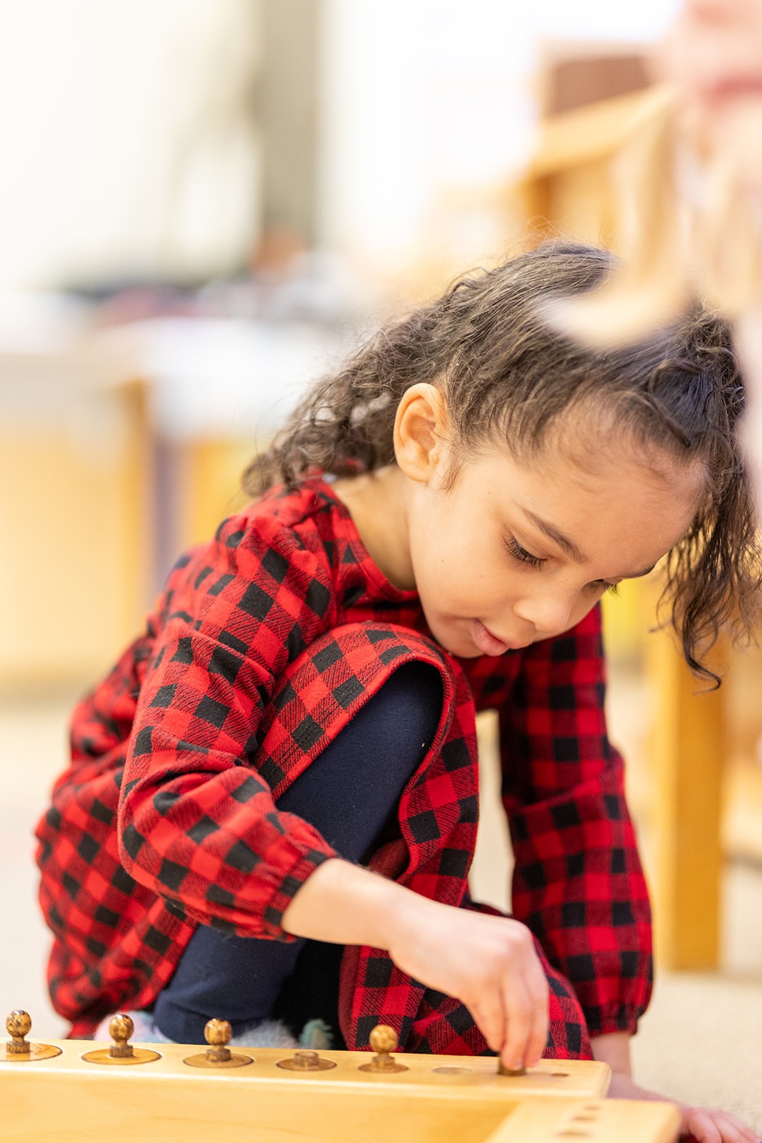 A student concentrating on Montessori materials
